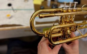 repair tech fixing trumpet